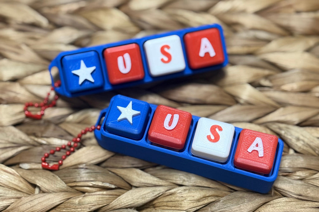 Two 'USA' keychains on a woven surface