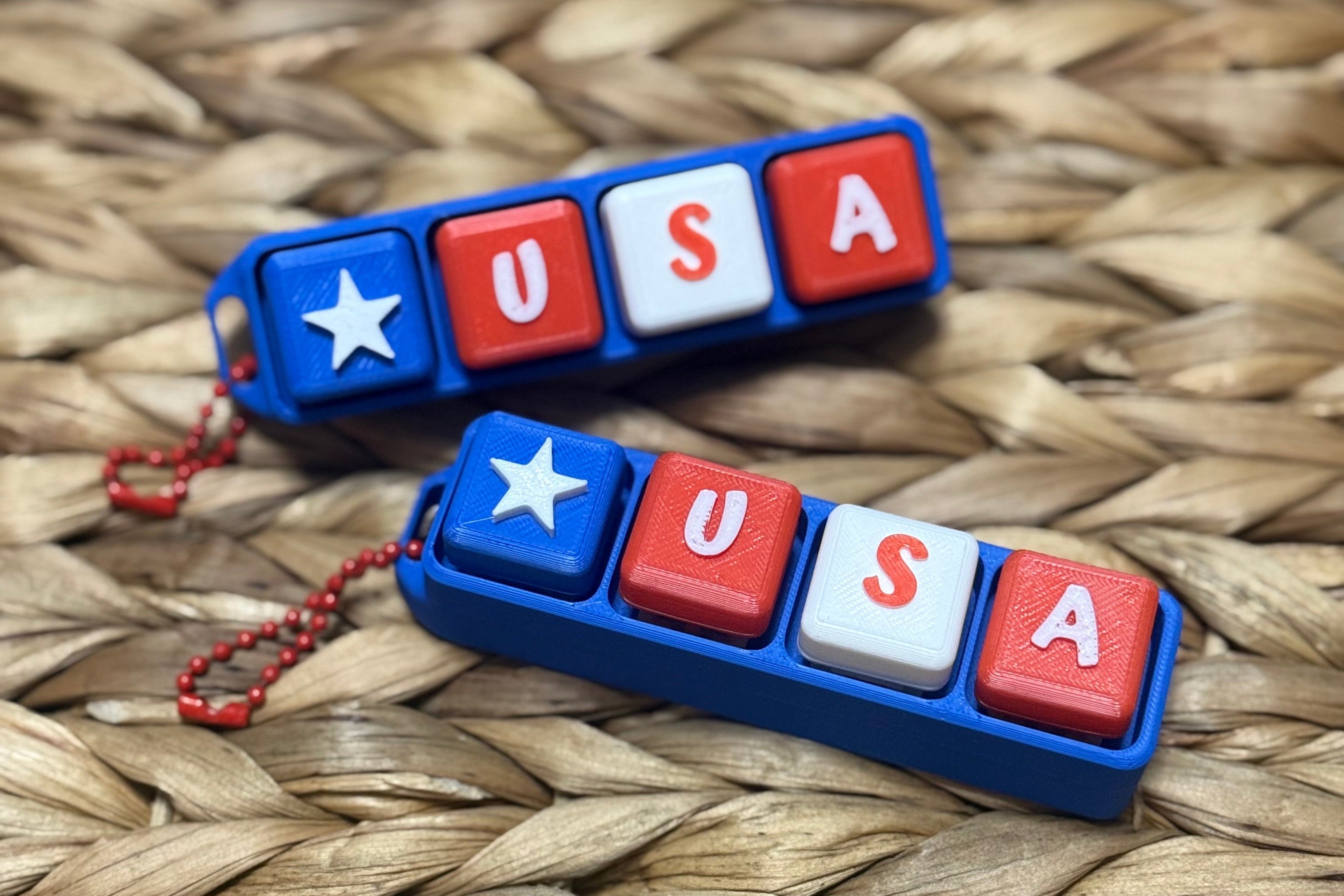 Two 'USA' keychains on a woven surface
