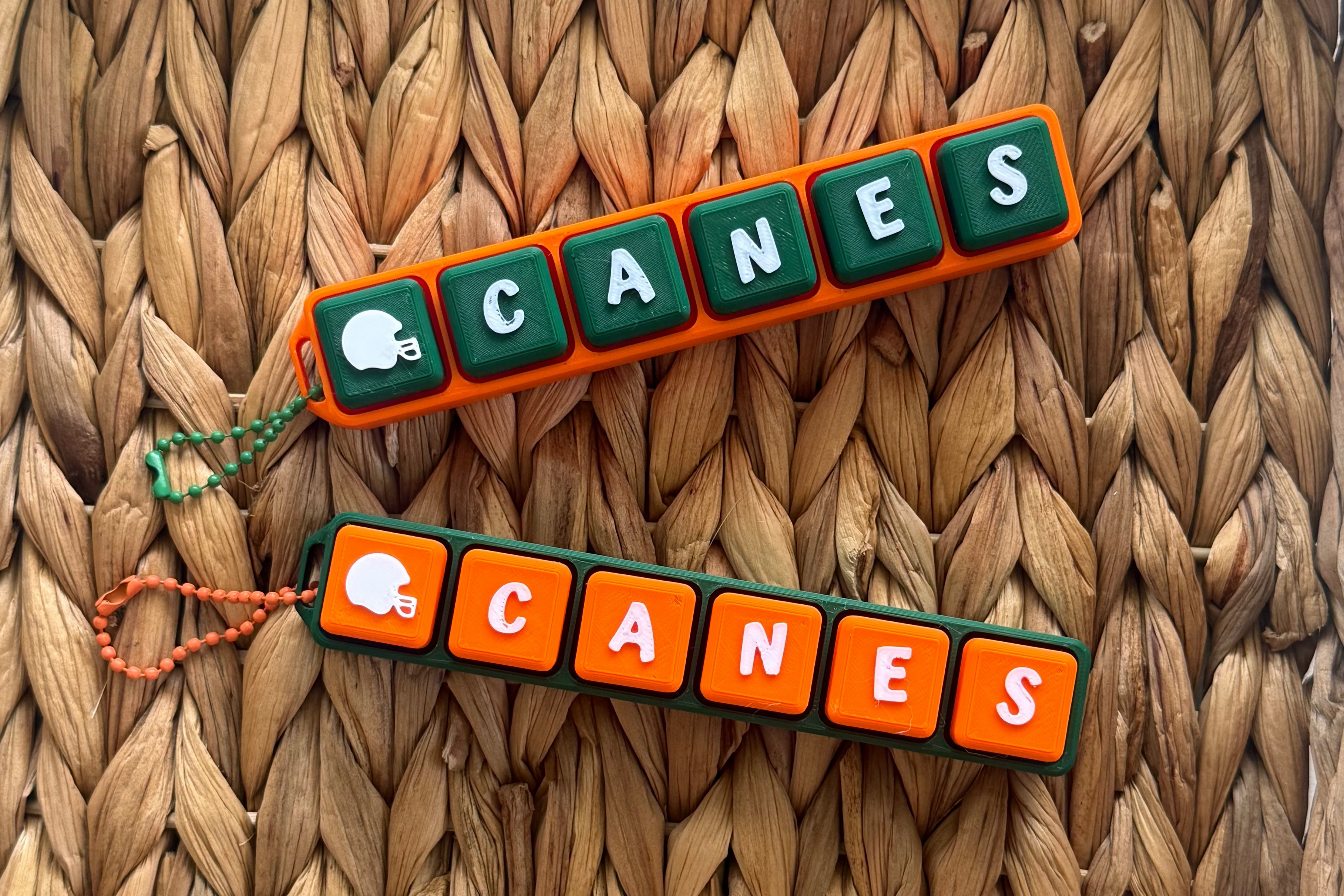 Two 'Canes' keychains on a woven surface