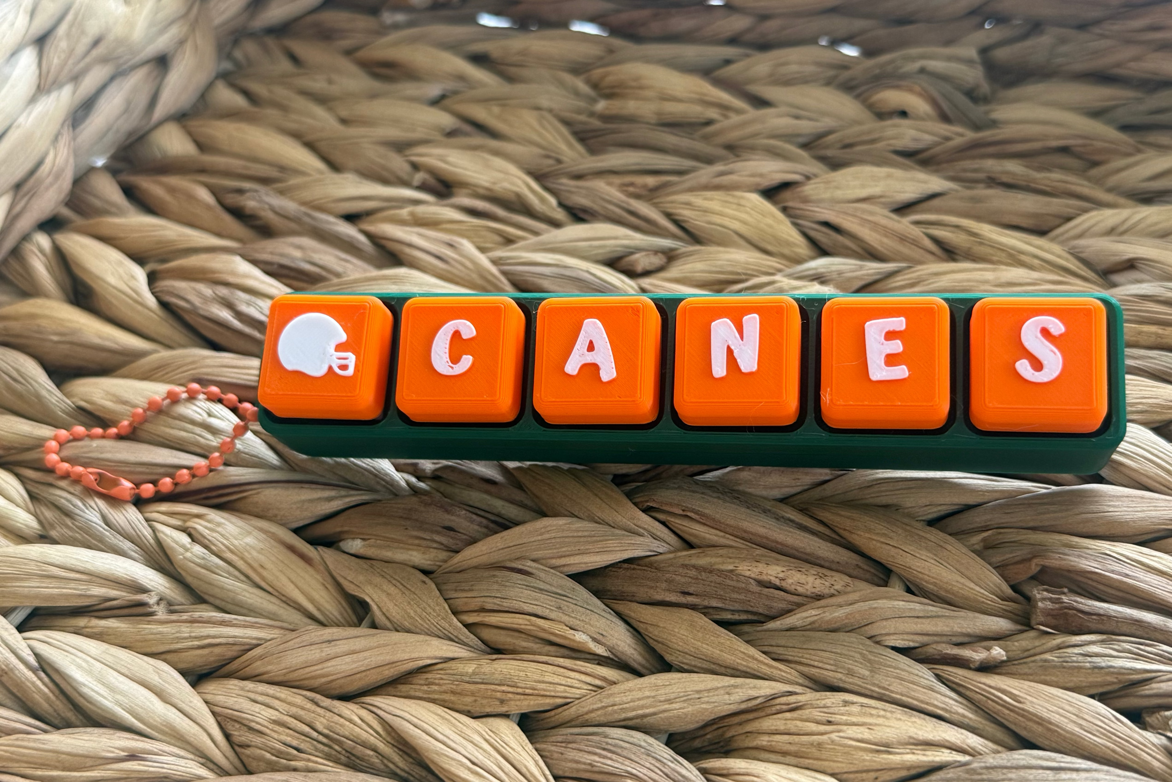 Keychain with 'CANES' letters on a woven surface