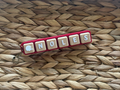 Keychain with letter tiles spelling 'NOLES' on a woven surface
