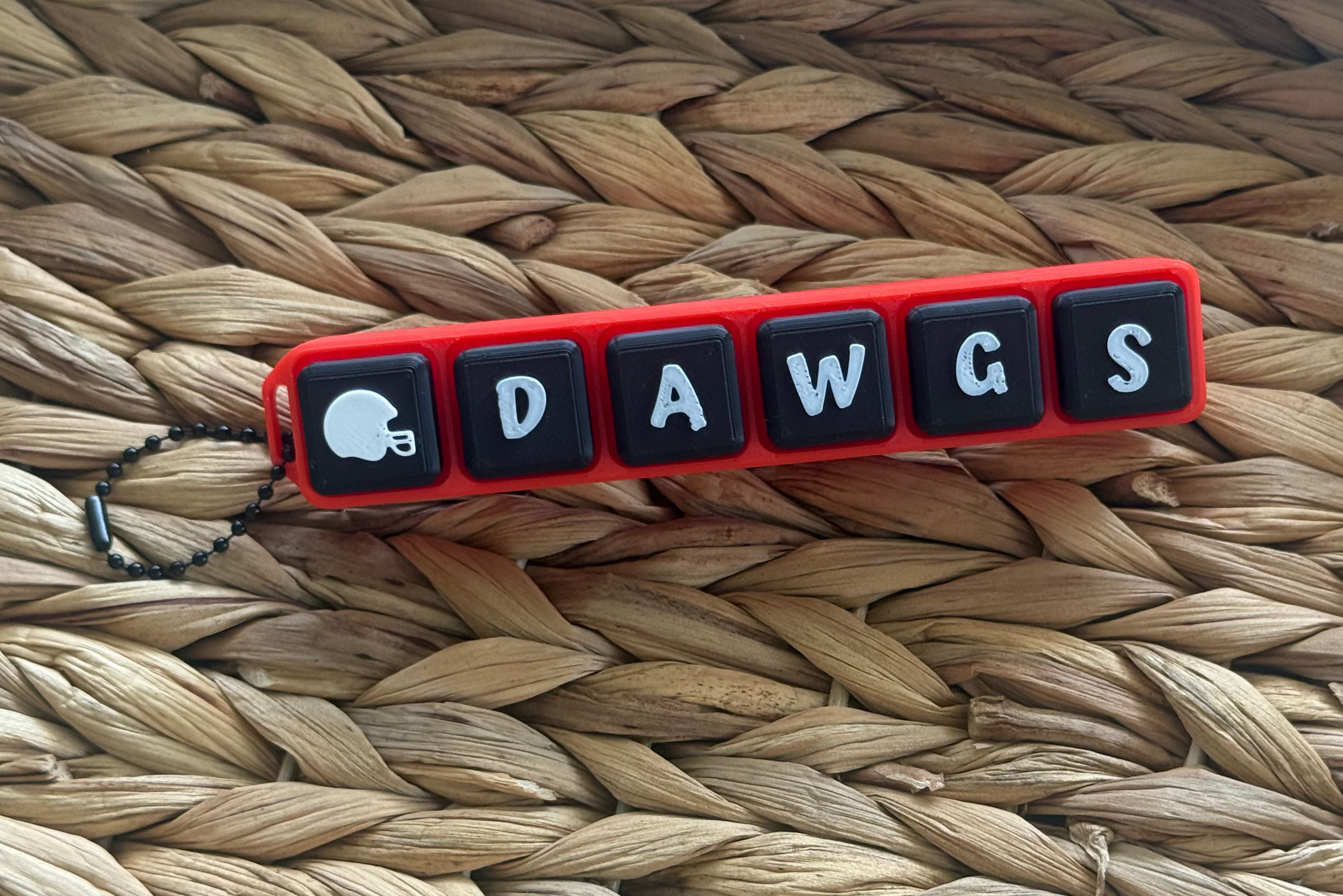 Keychain with 'DAWGS' letters on a woven surface