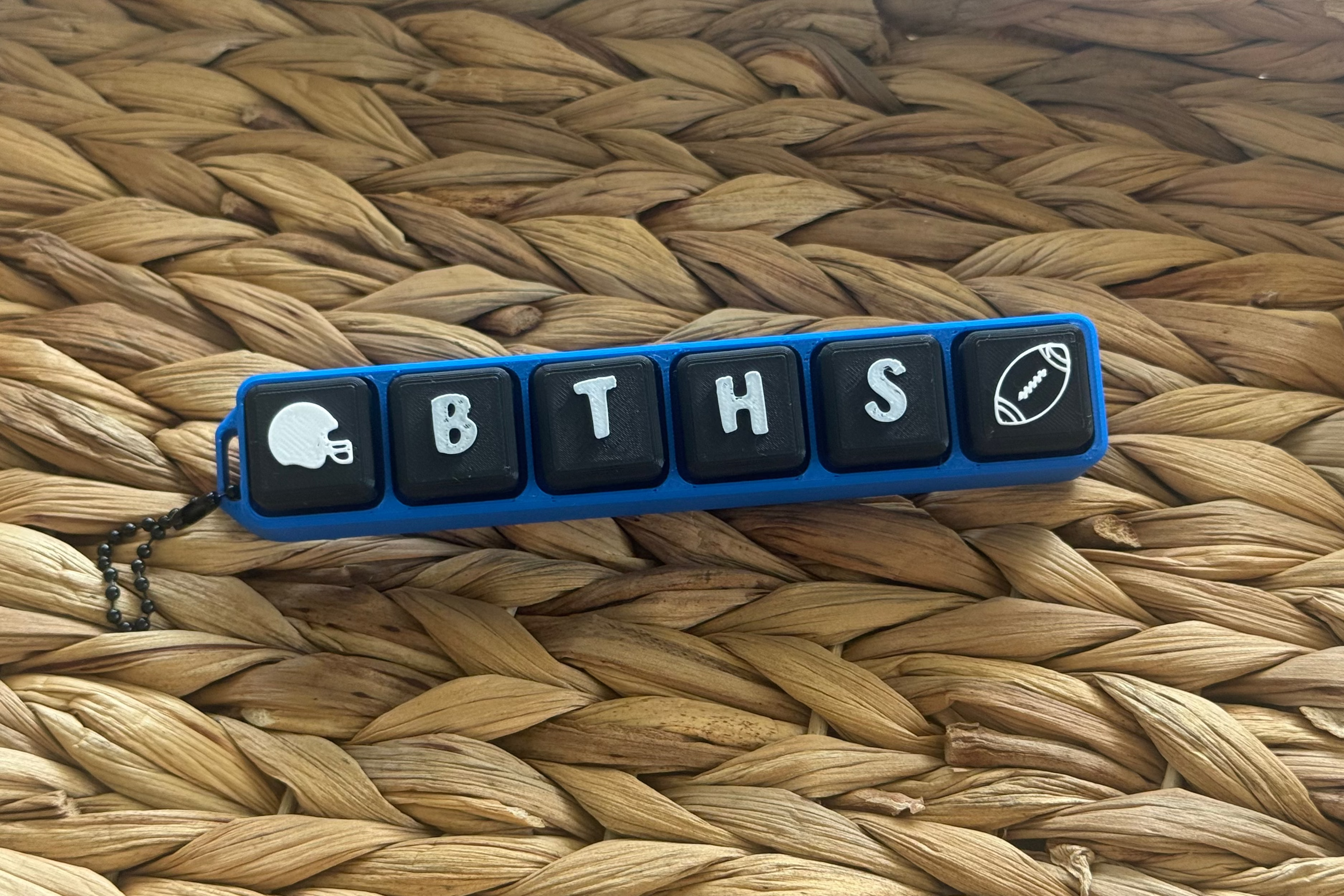 Keychain with letters 'BTHS' on a woven surface